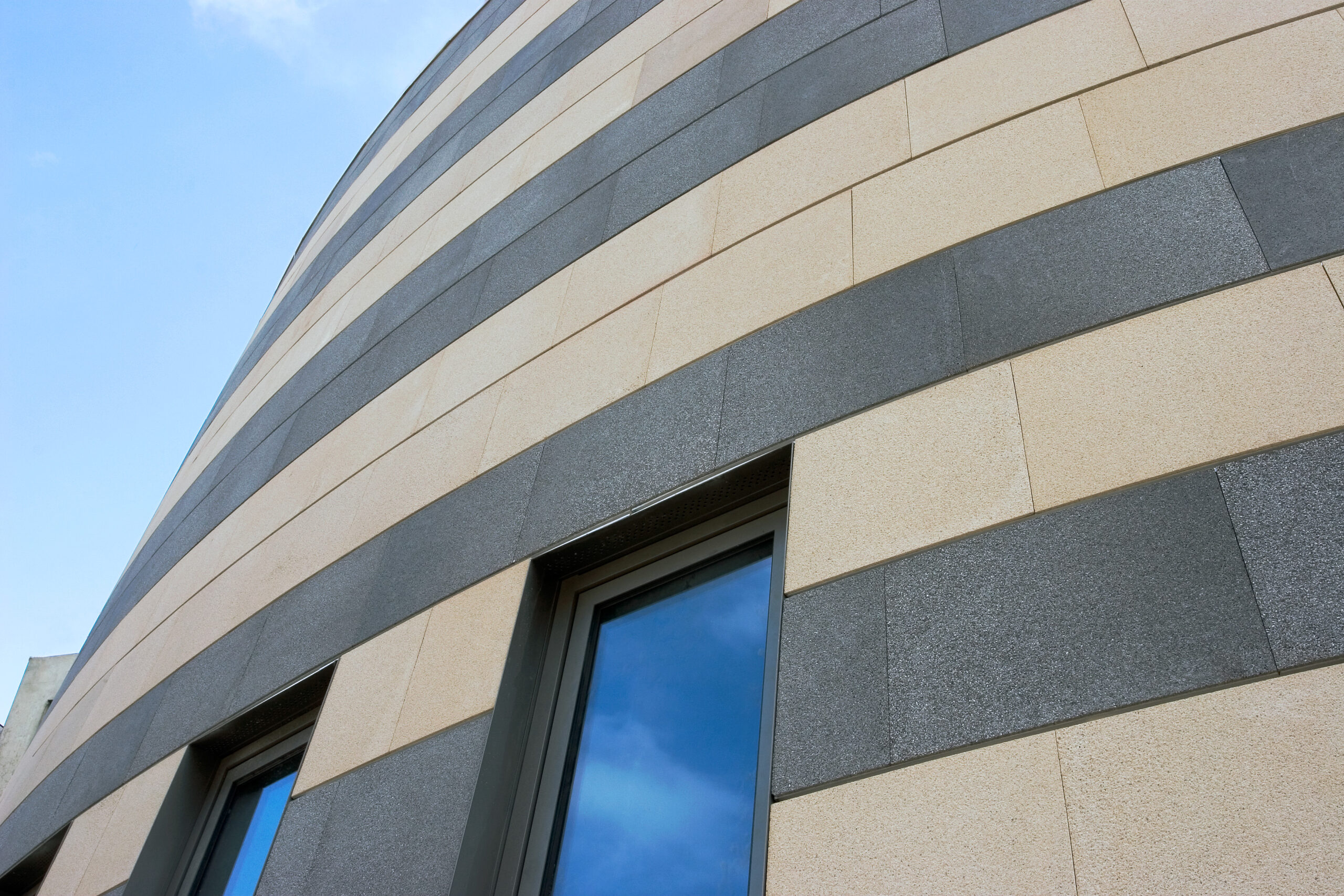 Façade architecturale en panneaux minéraux alternant teintes avec pose en bandes horizontales